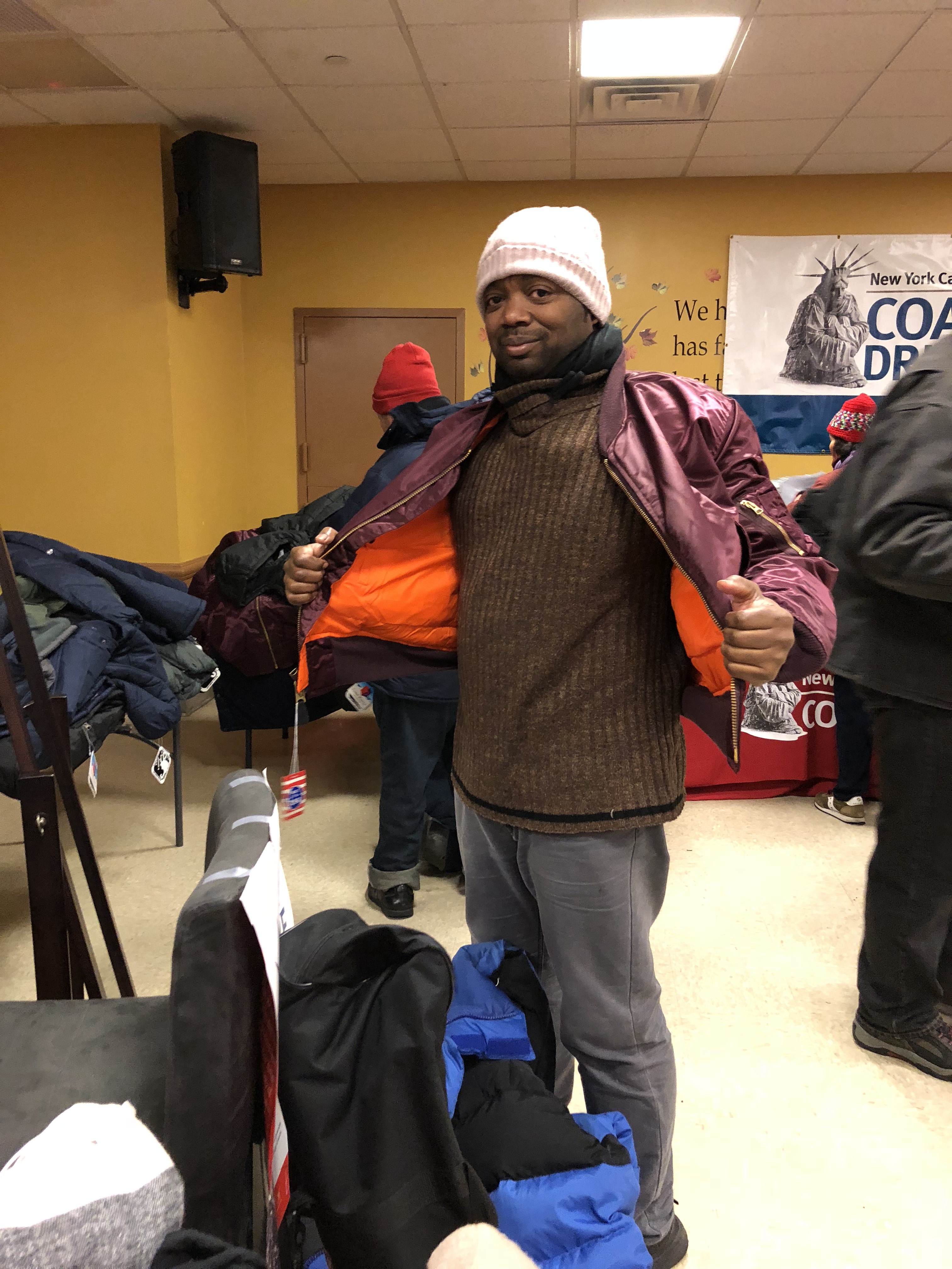 Male coat recipient trying on a warm coat