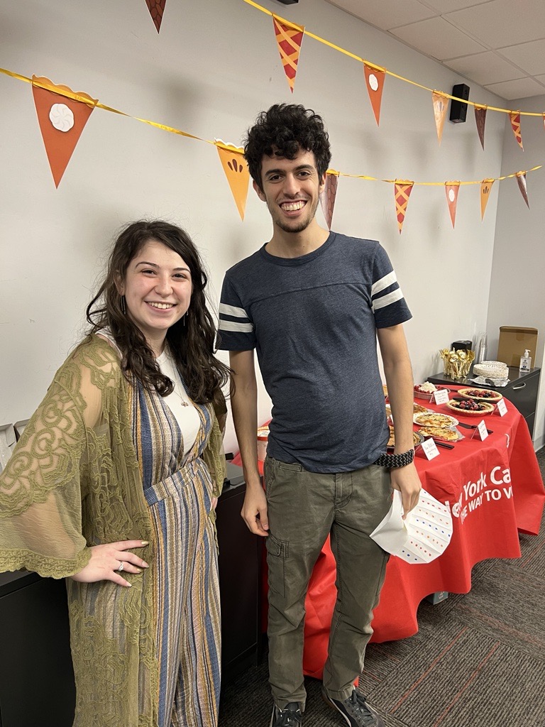 Two New York Cares staff members standing in front of pies made for All Staff Pi Day