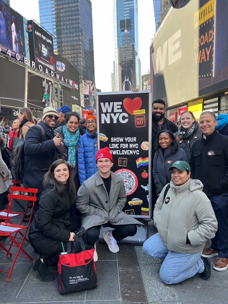 Group of New York Cares staff posing in Times Square during WE LOVE NYC kickoff event