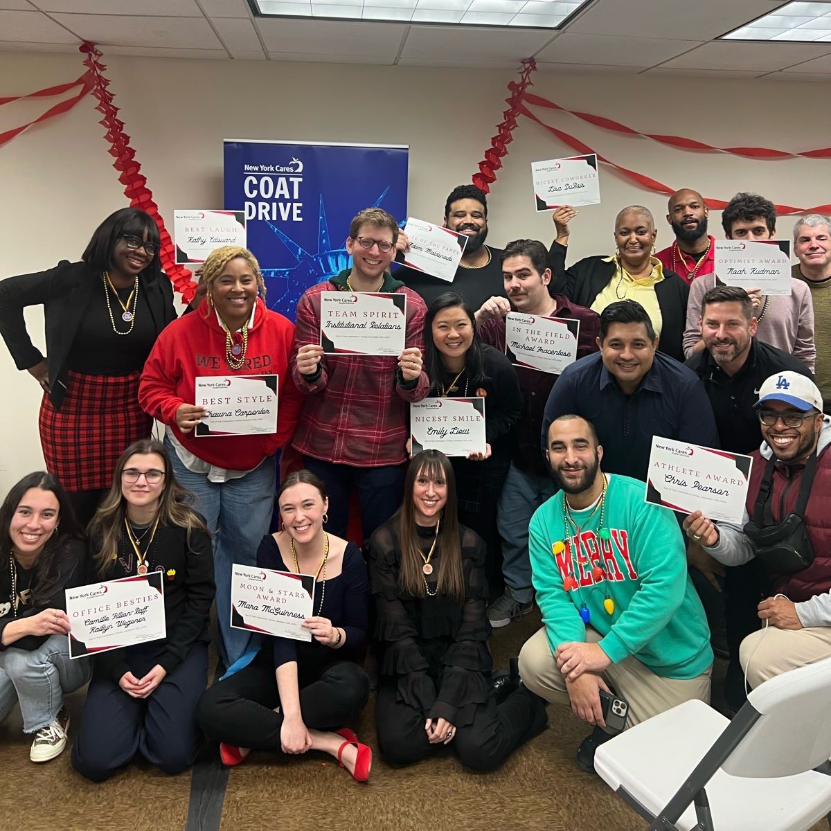 Group shot of New York Cares staff posing with staff certificates
