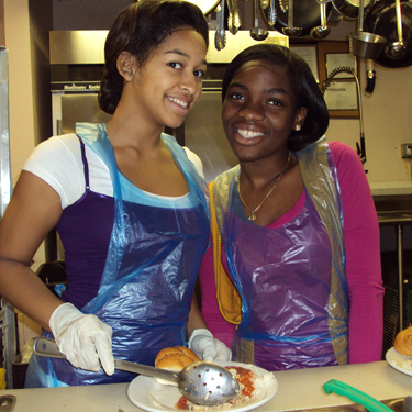 Two young volunteers serving meals