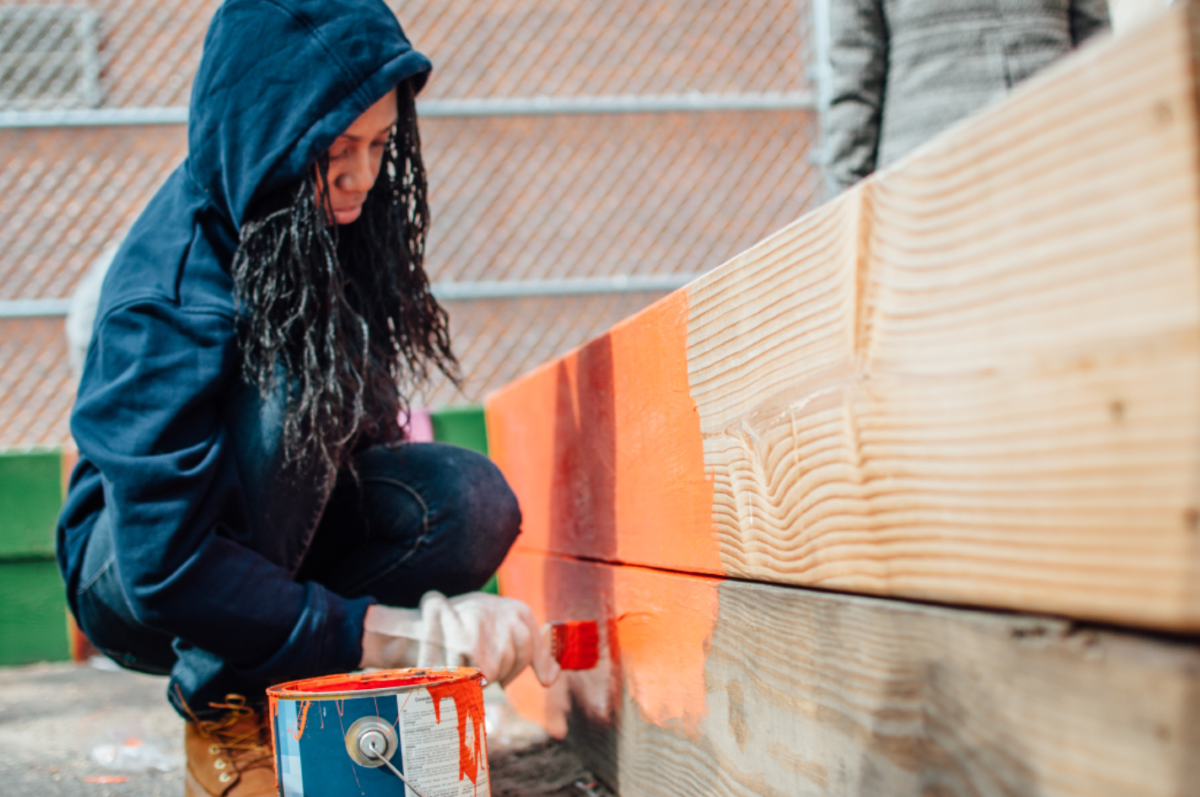 Volunteer painting a wood garden box