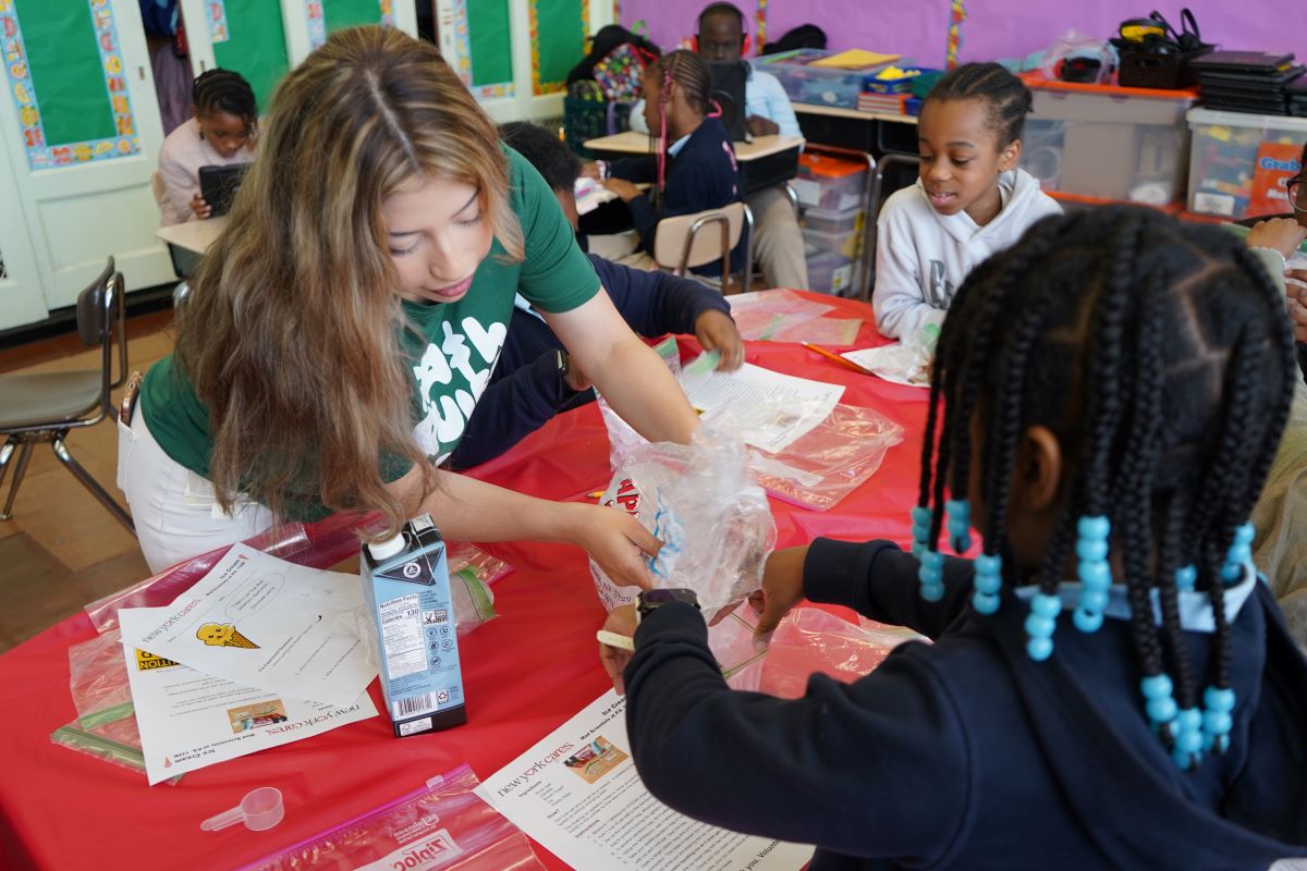 Volunteer helping student with science experiment